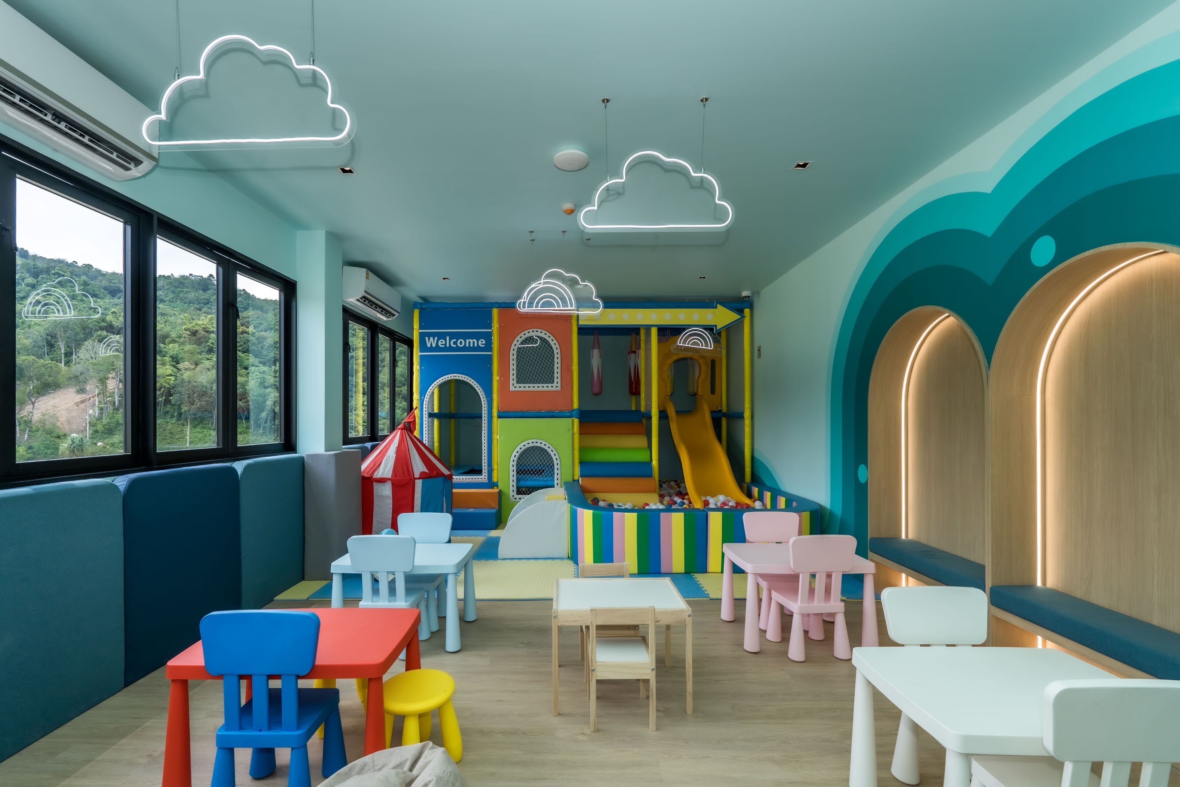 Zona de juegos infantiles con estructuras coloridas y asientos.