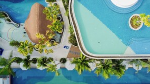 Vista aérea de un resort con varias piscinas, palmeras y zonas de descanso.