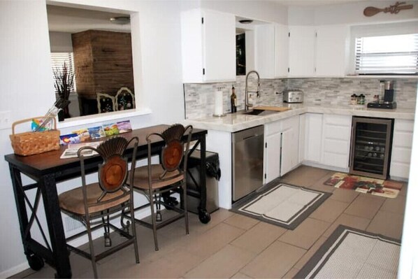 A compact kitchen with white cabinets, a built-in microwave, and a dishwasher.