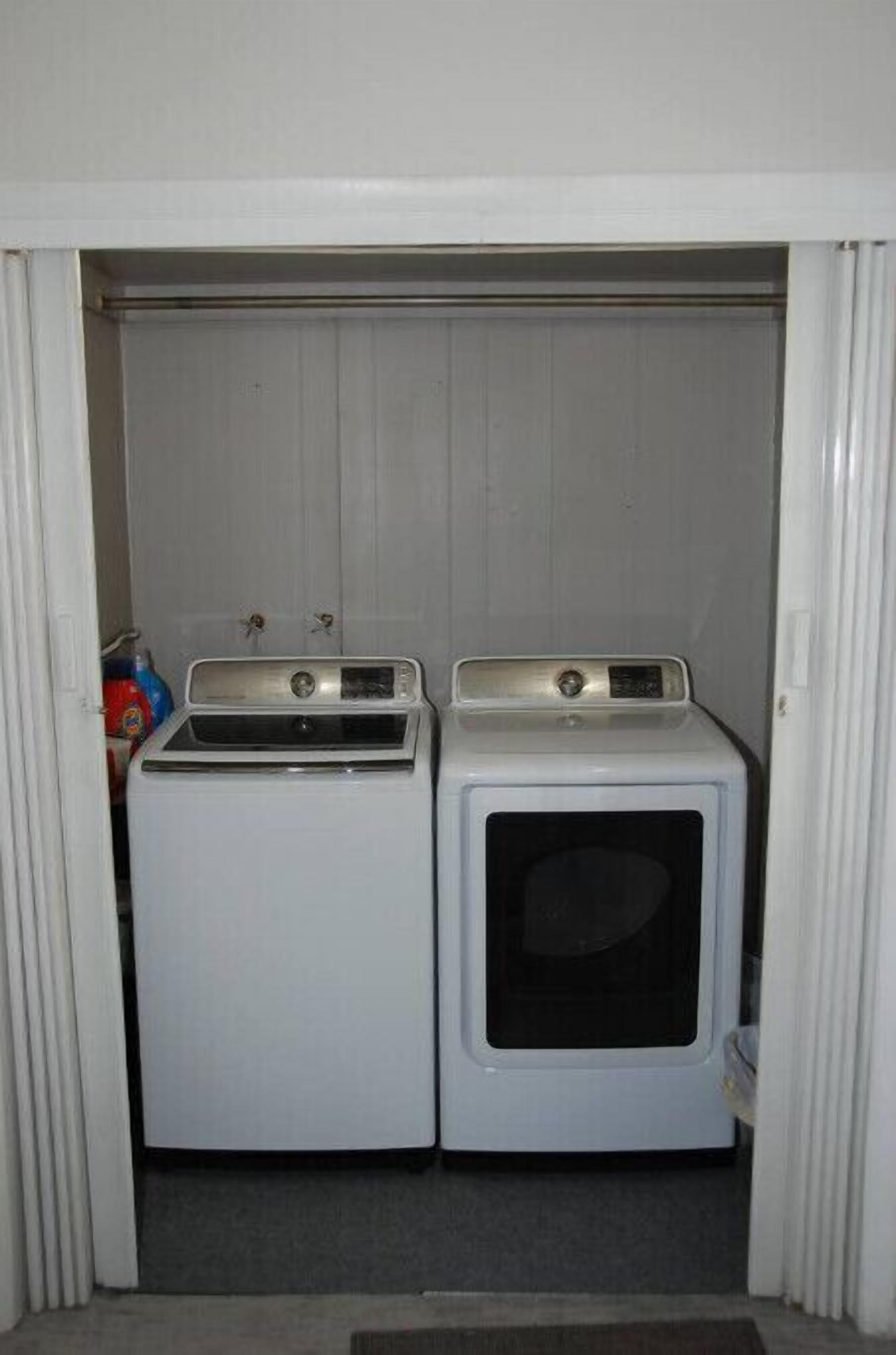 Une buanderie équipée de deux machines à laver et d’un sèche-linge.