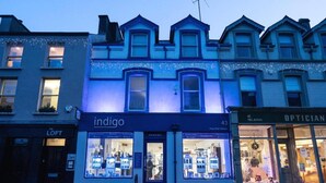 A building with a storefront labeled 'indigo' and 'OPTICIAN' across the street. - Indigo Apartment - Beautiful 1-bed in Ballycastle (Ballycastle)