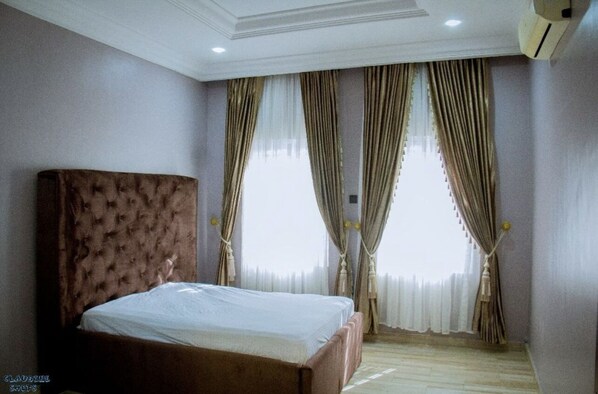 Relax in a spacious room with a large bed and large window, offering a view.