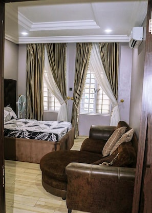 A bedroom with a bed, a sofa, and curtains. - Remarkable 3-bed Villa in Ajah Ogombo (Lekki)