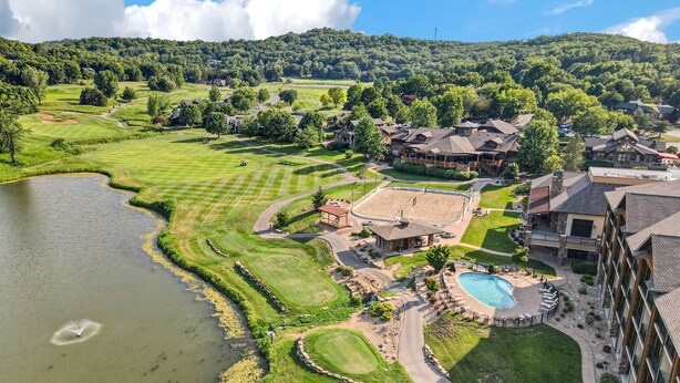 A golf course with a lake, a swimming pool, and residential buildings. - Cozy Cottage Inside the Premier Old Kinderhook Golf Resort (Camdenton)