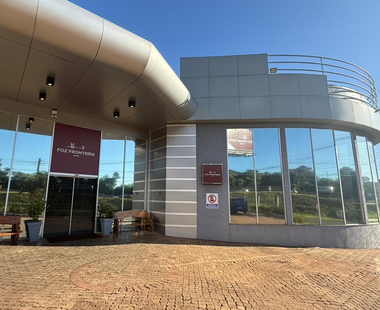 A building with a curved facade, a large glass window, and a sign for 'FOZ FRONTEIRA.'