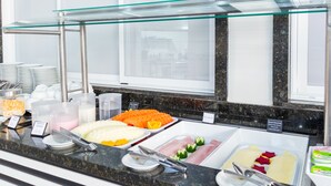 A buffet counter with various food items and utensils. - Foz Fronteira Hotel (Foz do Iguaçu)