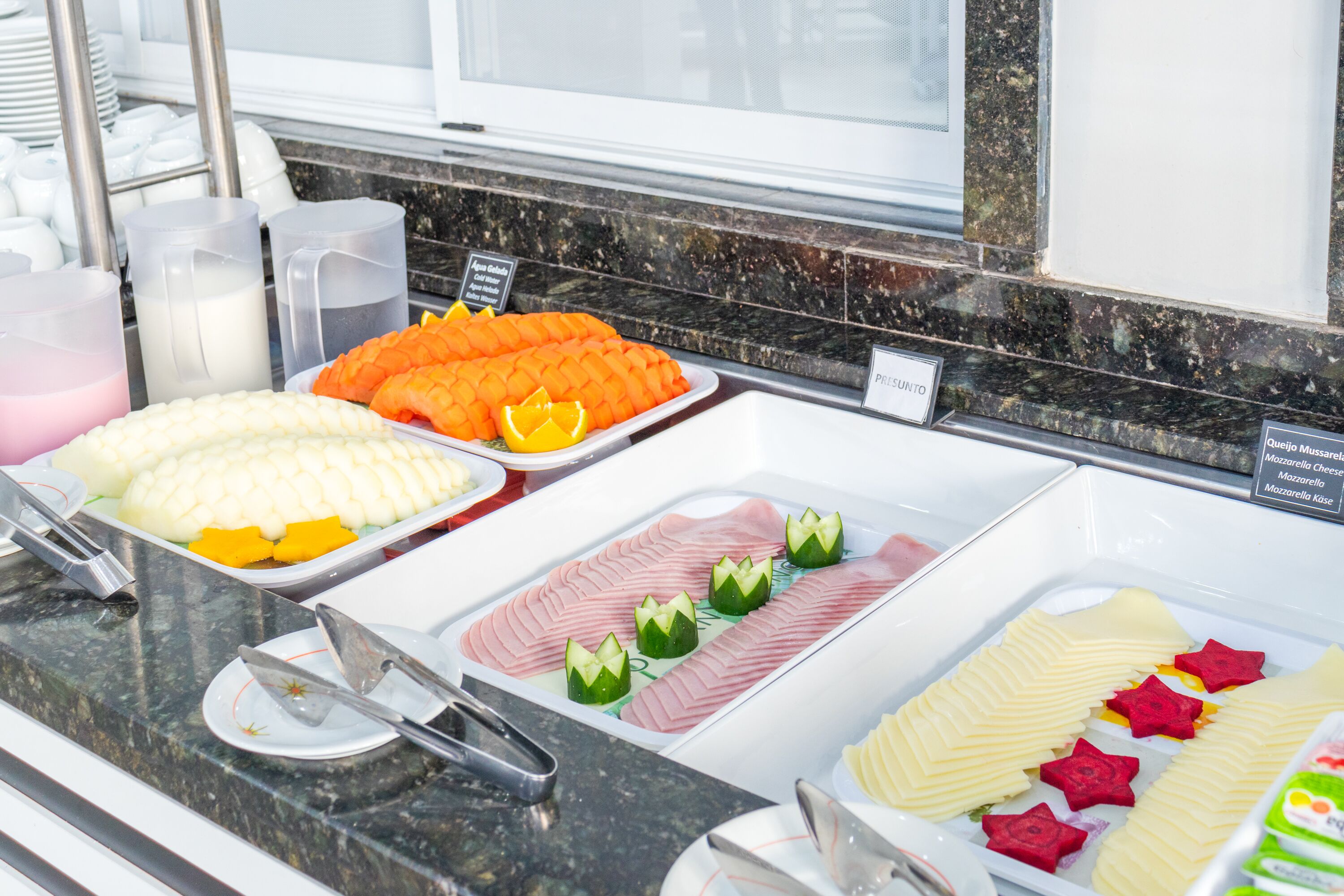 Ein Buffet mit verschiedenen Speisen, darunter Obst, Gemüse und Käse.