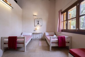 A room with two single beds, a small table with a lamp, and a window with curtains. - 3 bedroom villa with private pool (Mancor de la Vall)