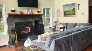 Una sala de estar con chimenea, sofá, una mesita de centro y una estantería.