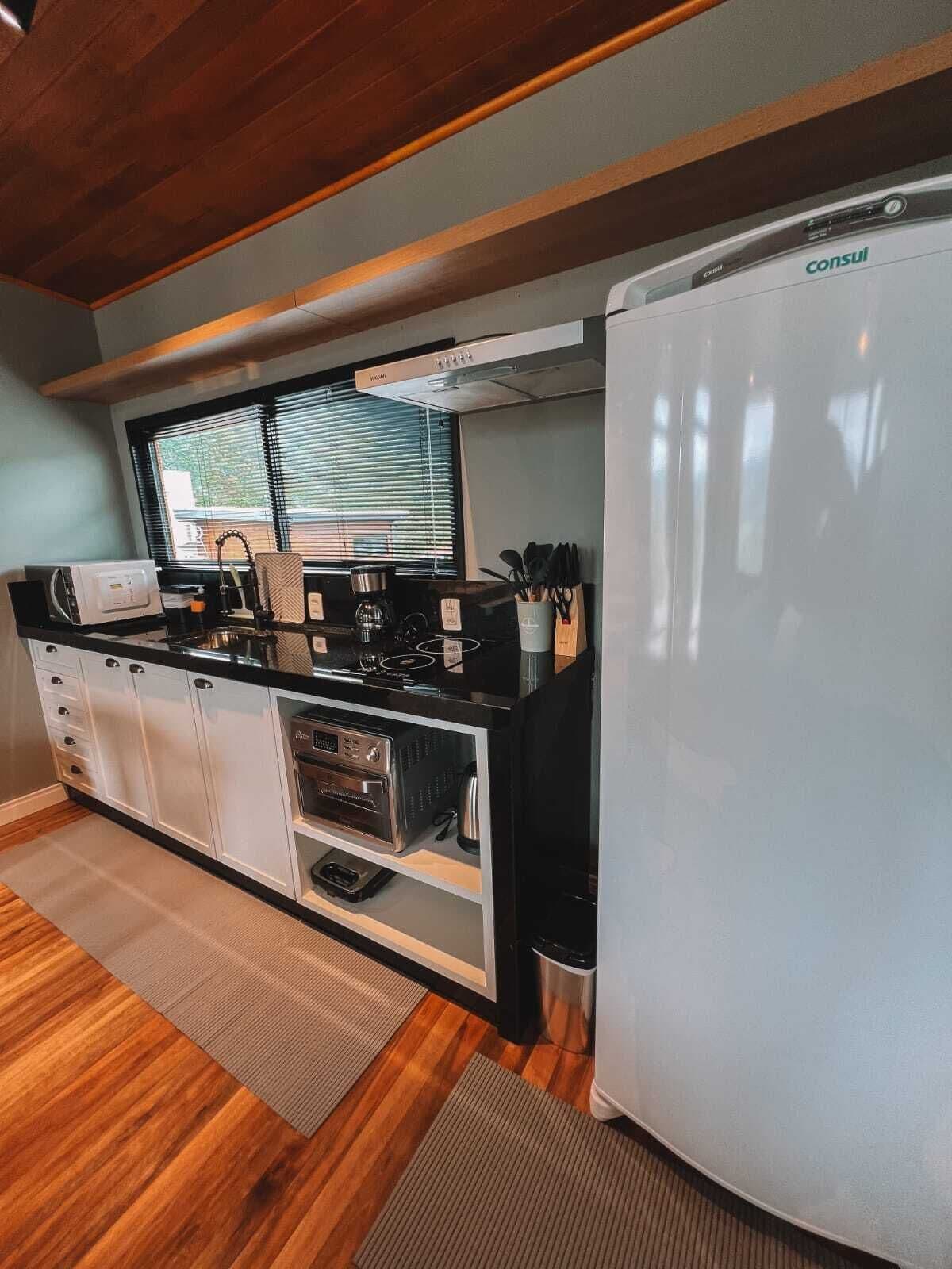 Une cuisine compacte équipée d’un réfrigérateur, d’un four à micro-ondes, d’une cuisinière et d’un four.
