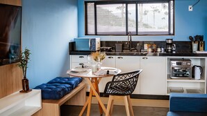 A compact kitchen with a dining area, featuring a microwave, toaster, and coffee maker. - Parador do Rei (Urubici)