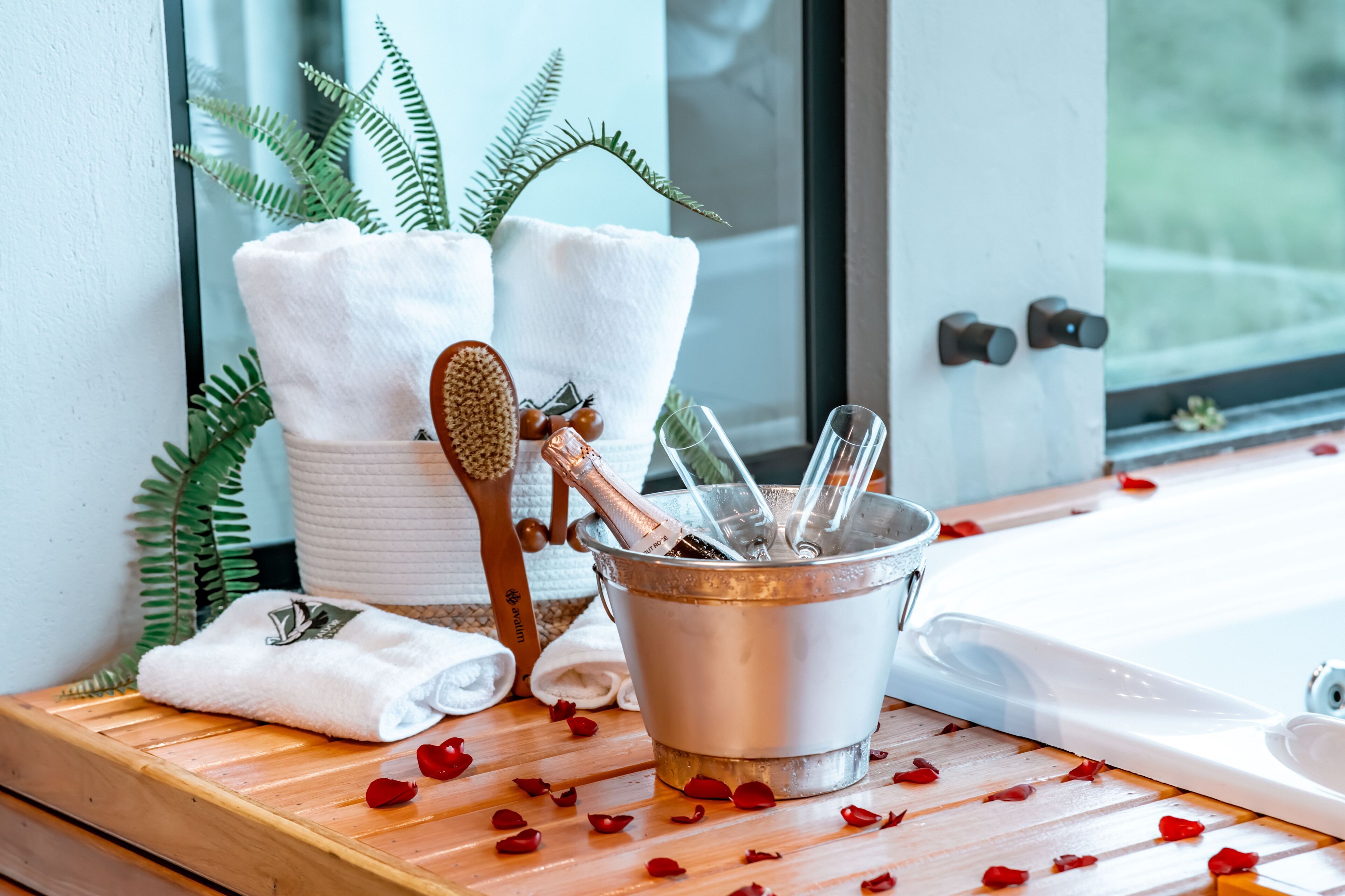 A spa area with a wooden bench, a bucket with a brush and a bottle, and towels.