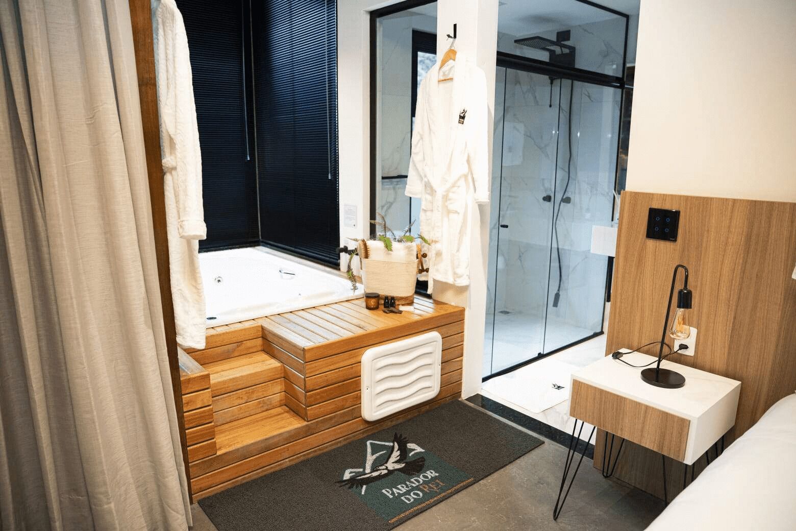 A modern bathroom with a wooden vanity, a bathtub, and a shower area.