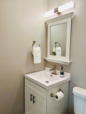 A bathroom with a white sink, a mirror, a towel rack, and a toilet. - Corporate Rental in Merrillville (Merrillville)