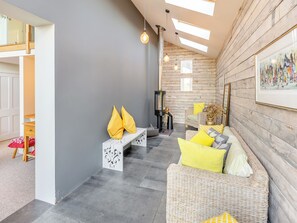 A modern living room with a fireplace, a sofa set, and a bench.
