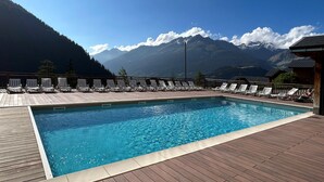 A swimming pool with lounge chairs and a mountain view. - Apt 4 ppl, balcony, near the ski runs (Modane)