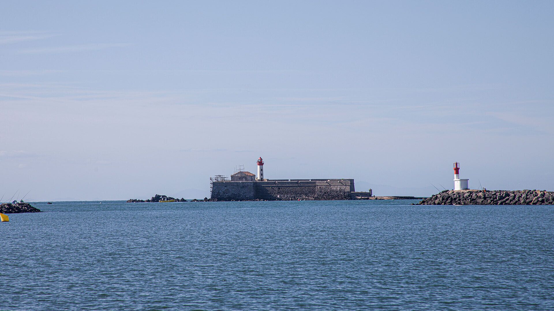 Una estructura de faro en la costa, con una vista despejada del agua y la costa rocosa circundantes.