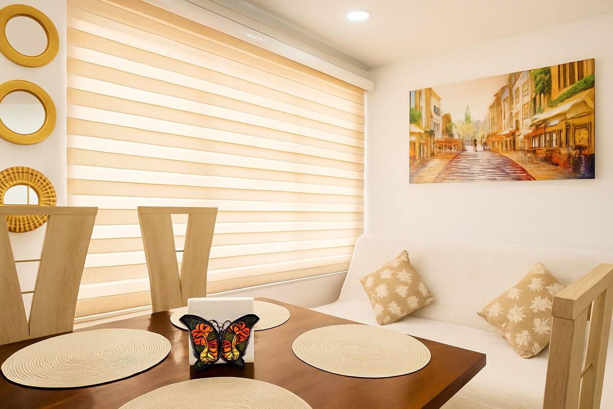 Un coin repas avec une table en bois, des chaises et une décoration centrale en forme de papillon.