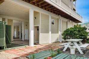 A covered outdoor area with a picnic table, a green bench, and a small garden area. - Florida Abode - Private Beach Access & Ocean Views (Alligator Point)
