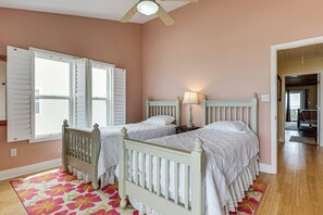A bedroom with two beds, a ceiling fan, and a window with shutters. - Florida Abode - Private Beach Access & Ocean Views (Alligator Point)