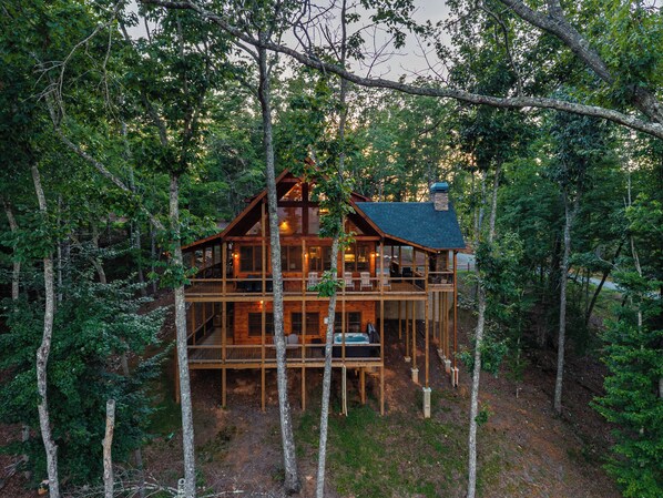 A cabin with multiple levels, surrounded by trees.
