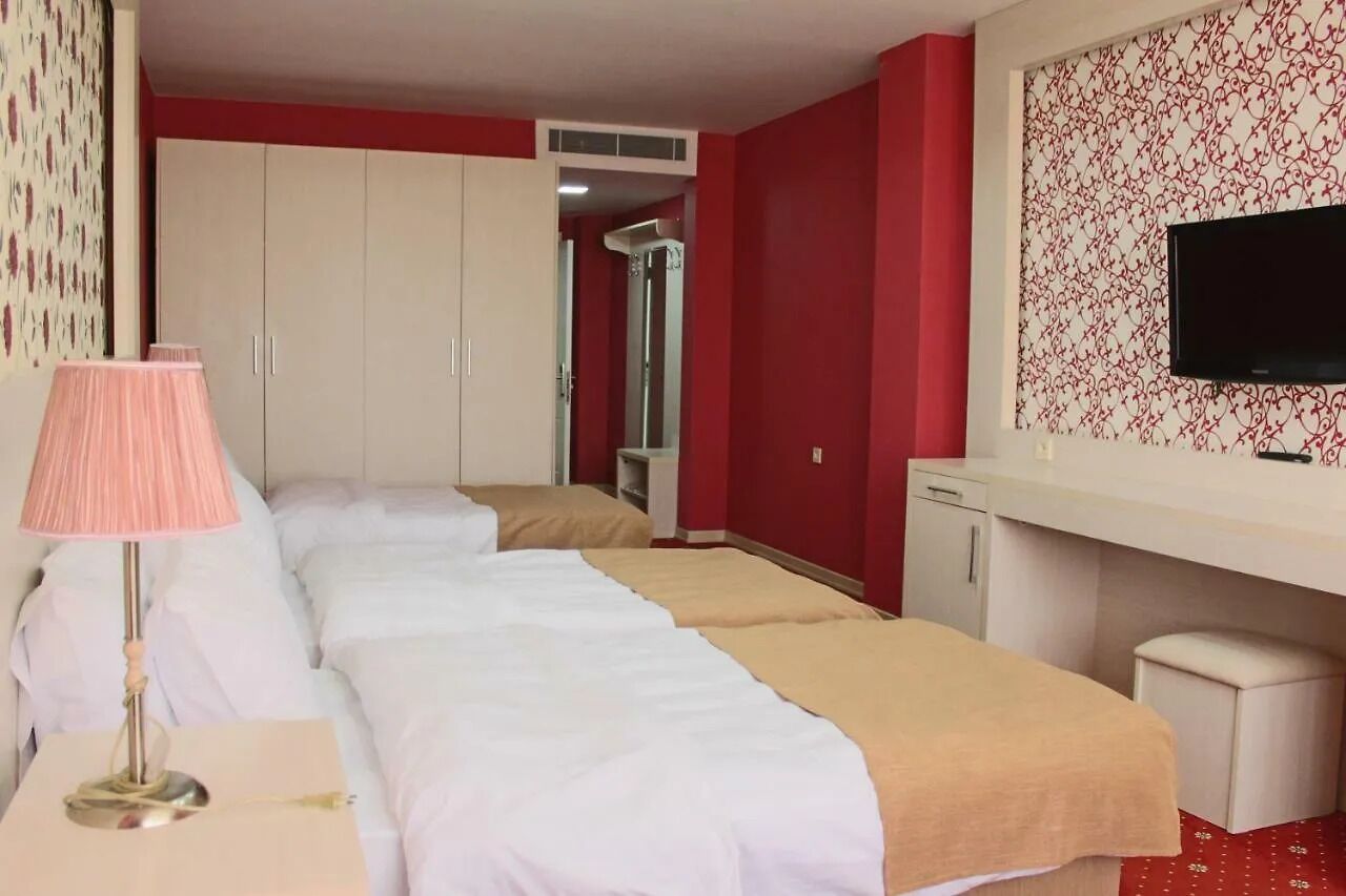A hotel room with two beds, a TV, a desk, and a wardrobe.