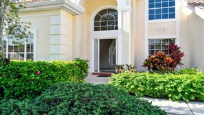 A two-story house with a front entrance, a covered porch, and a large arched window. - Altaira - Top Location, Lake View, Pool, Spa,4 Bed (Naples)