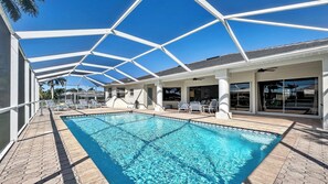 Piscina con techo de vidrio, sillas de descanso y zona de terraza.