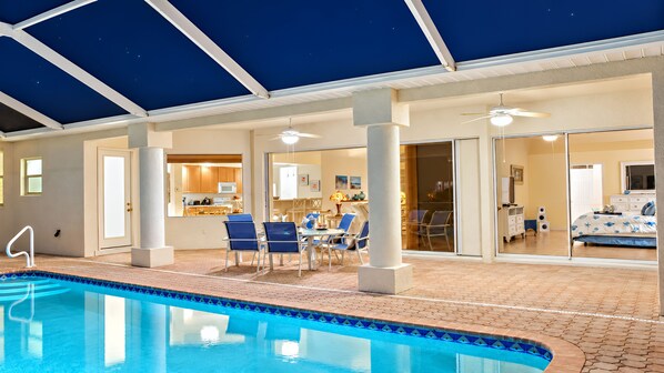 An indoor swimming pool with a clear view of the adjacent dining area and kitchen.