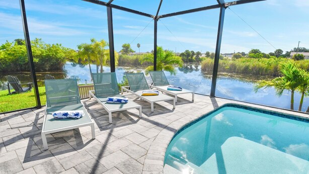A poolside area with lounge chairs and a view of a lake. - Phoenix, quite Area, Pool and great water few (Cape Coral)