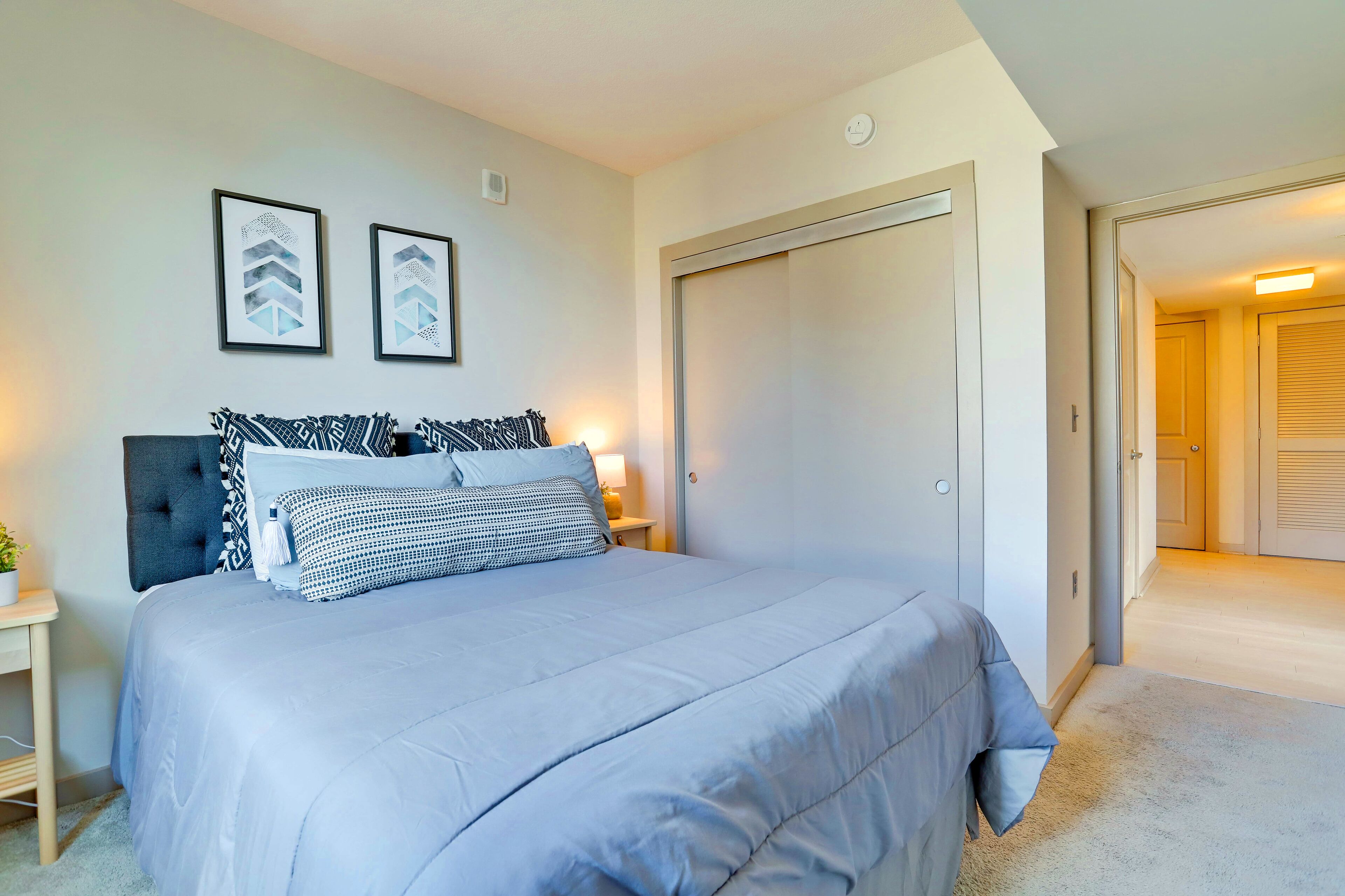 A bedroom with a bed, bedside tables, and a wardrobe.