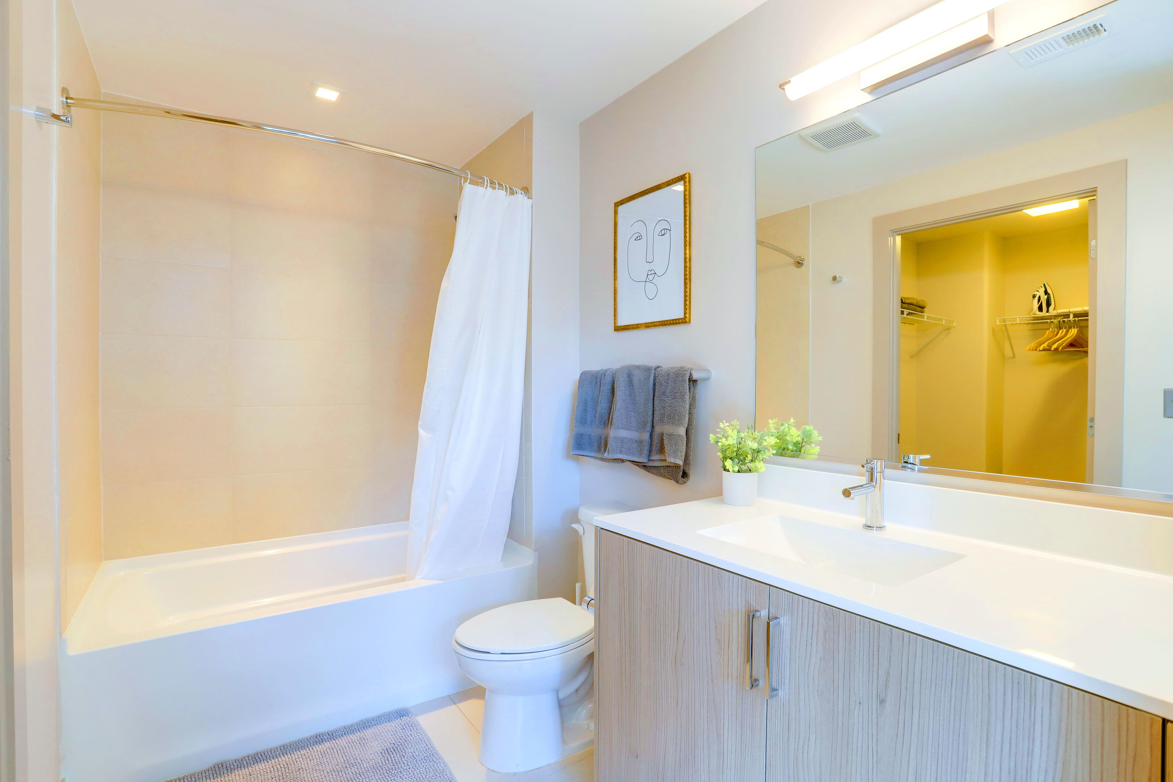 A modern bathroom with a bathtub, toilet, and vanity.