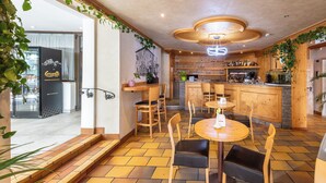 A restaurant with wooden furniture, a bar area, and a view of the street. - VILLA NUOVA (Romeno)