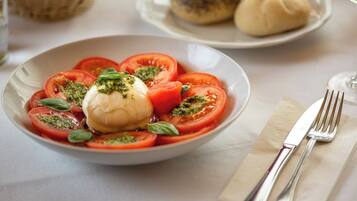 Ein Teller mit Caprese-Salat, bestehend aus Tomaten, Mozzarella und Basilikum.