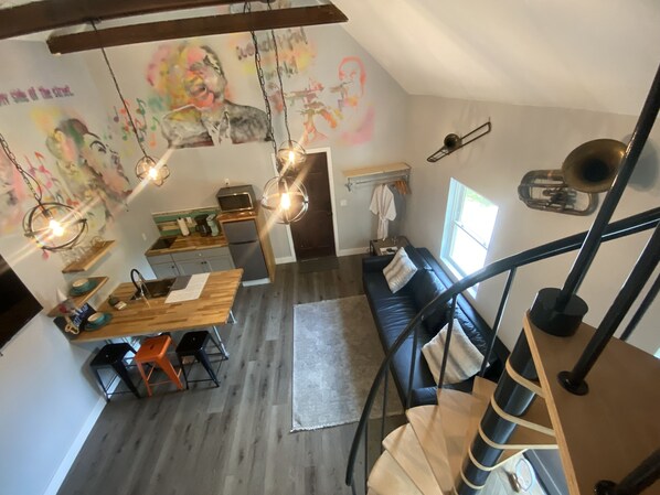 A cozy loft-style apartment with a kitchen, dining area, and living space. - The Jazz Loft (Sanford)