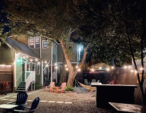 A backyard with a hammock, outdoor seating, and string lights. - The Jazz Loft (Sanford)