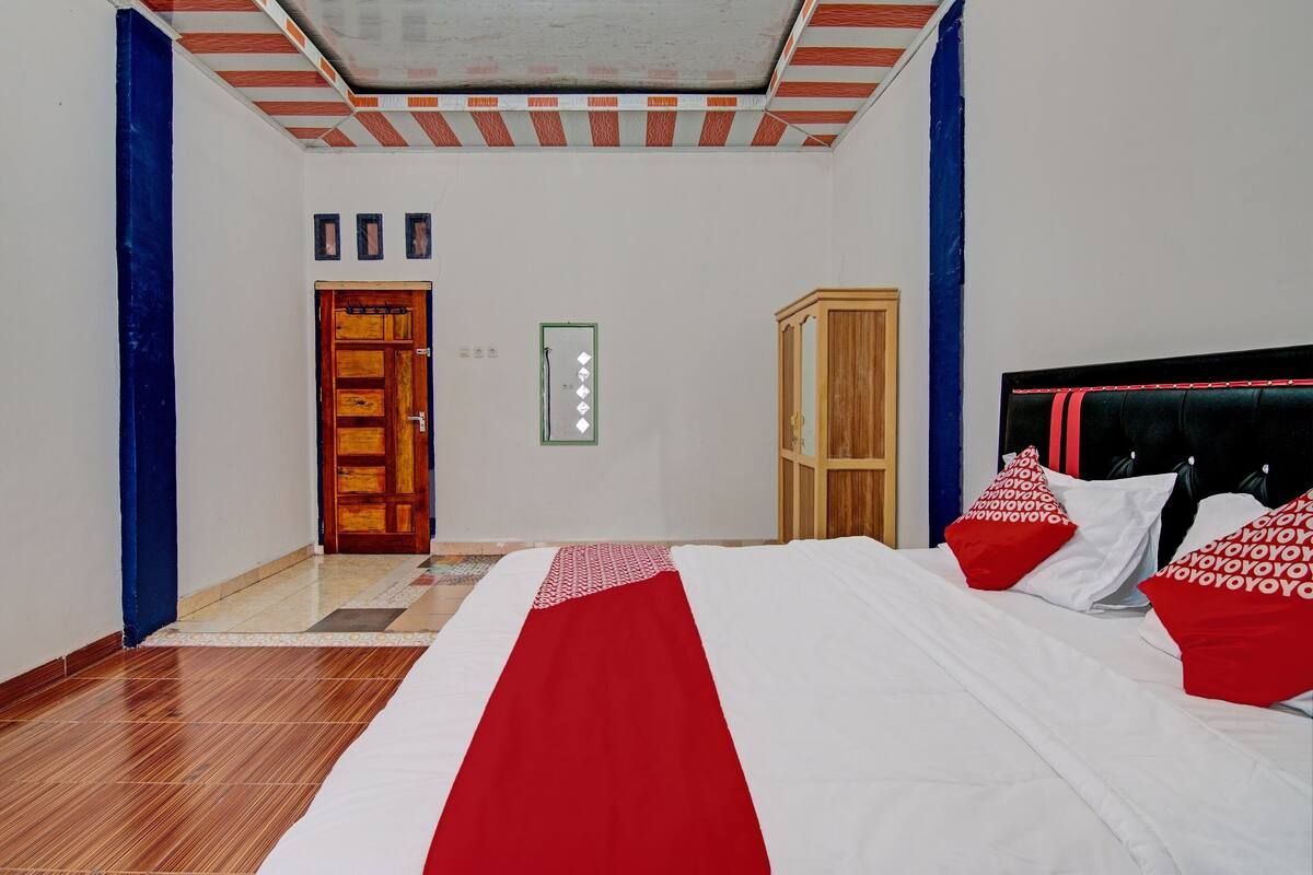 Une chambre à coucher avec un lit, une armoire et une porte.