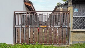 A gated entrance with a metal gate and a wooden fence.