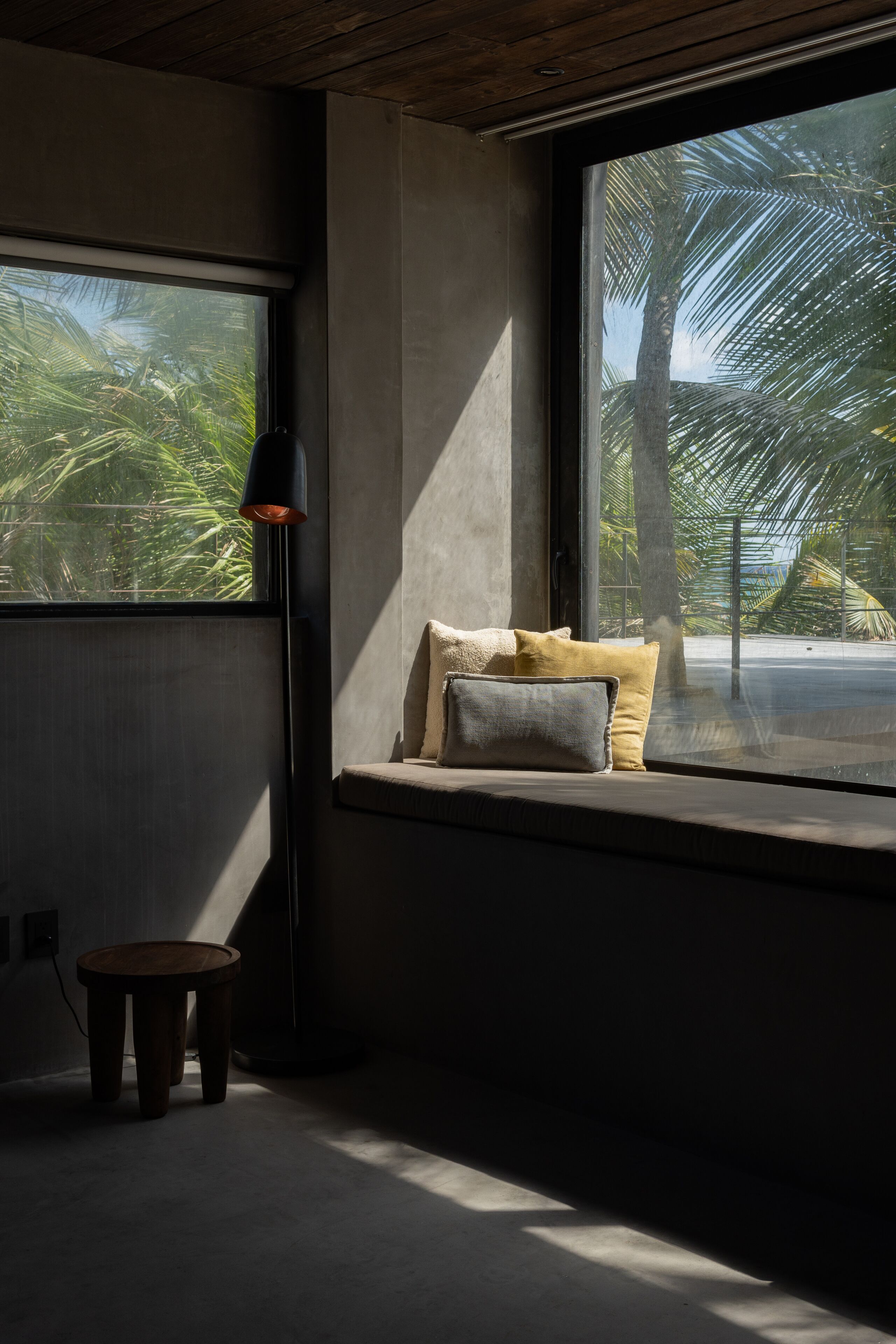 A room with a large window, a small table, and a lamp.