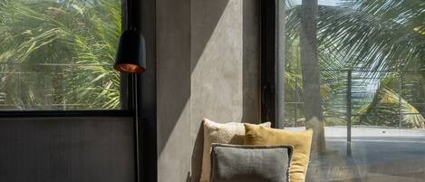 A room with a large window, a small table, and a lamp.