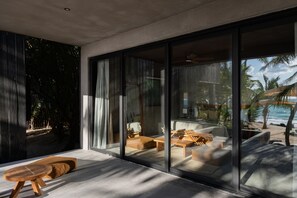 A modern living room with large glass doors, a wooden bench, and a sofa.