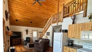 A spacious living area with a wooden ceiling, a dining table, and a kitchen with wooden cabinets and appliances. - Gorgeous Lake View with Pontoon!

 (Park Rapids)