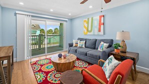 A living room with a sofa, coffee table, and a colorful rug. - Surfs Up - 1 Block to Beach & Walk to Dining (Flagler Beach)