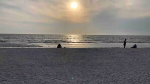 A beach with the sun setting over the horizon. - Indian Rocks Gem: Walk to Beach and Dining from Cozy retreat! (Indian Rocks Beach)