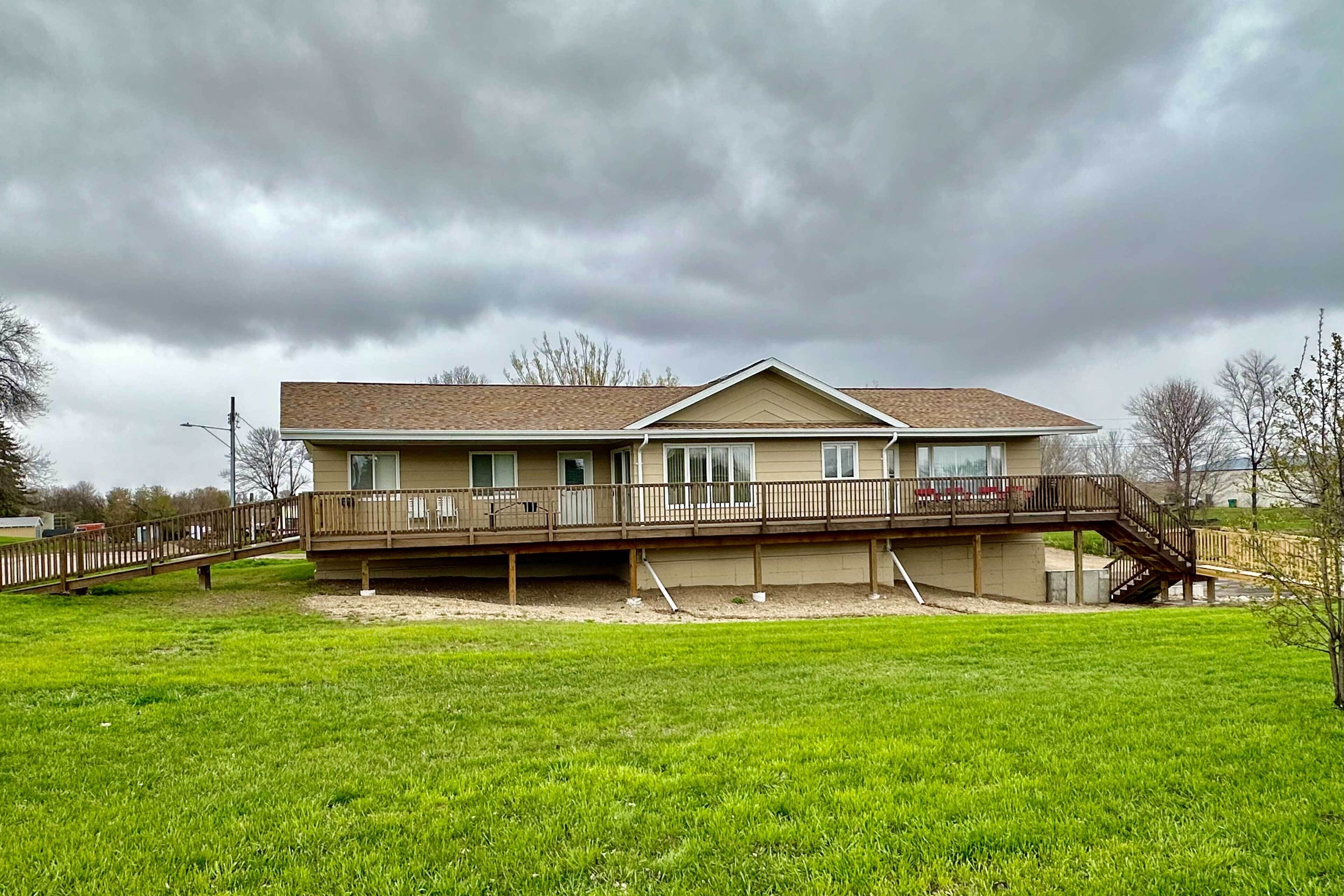 A two-story house with a deck, a covered porch, and a staircase leading to the upper level.
