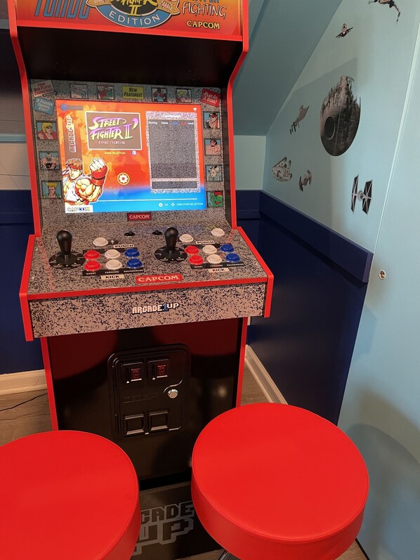 Una máquina de videojuegos de Capcom con el juego Street Fighter II mostrando una selección de personajes y botones de control.