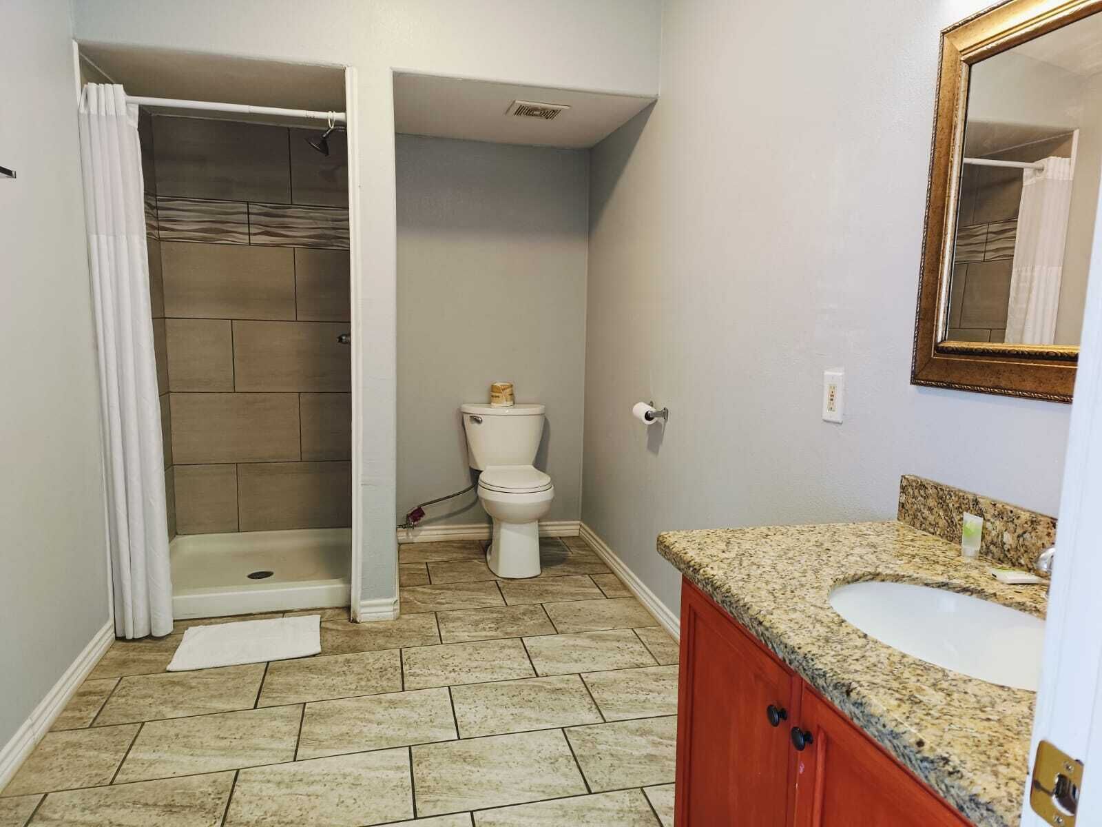 Un baño con ducha, inodoro y lavamanos.