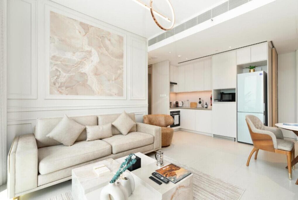Ein modernes Wohnzimmer mit einem beigen Sofa, einem Couchtisch und einem großen abstrakten Gemälde an der Wand.