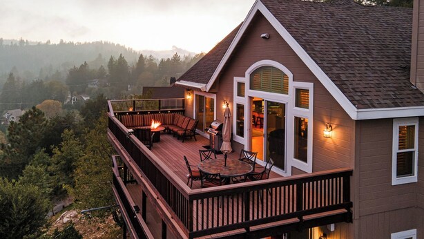 Una casa con terraza, mobiliario exterior y vistas del paisaje circundante.