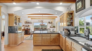Una cocina amplia con armarios de madera, una isla grande y vistas al exterior.